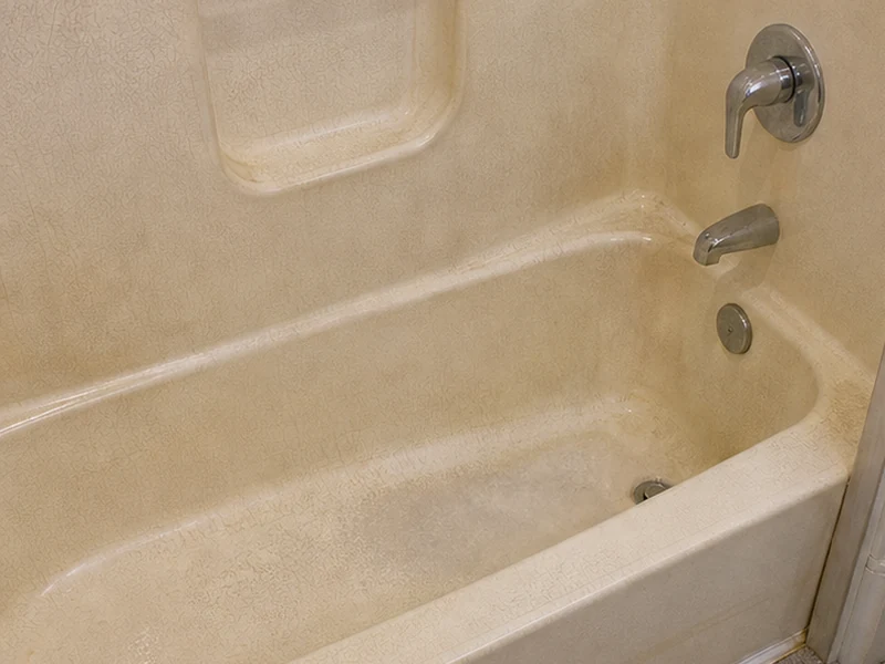Faded crazed fiberglass tub with yellowed gelcoat in a Lawrence Station condo, Santa Clara