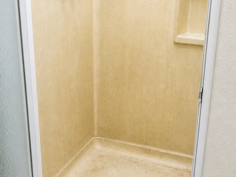 Faded fiberglass shower stall with crazing and a cracked pan before refinishing in a Lawrence Station condo, Santa Clara