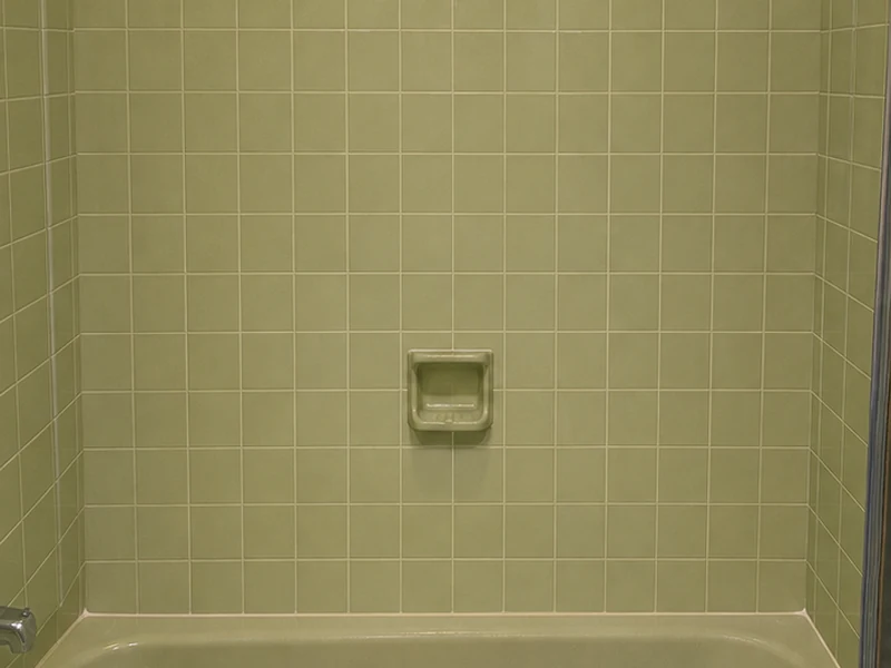 Dated avocado-green ceramic tub-surround tile before reglazing in a Forest Park Santa Clara bathroom